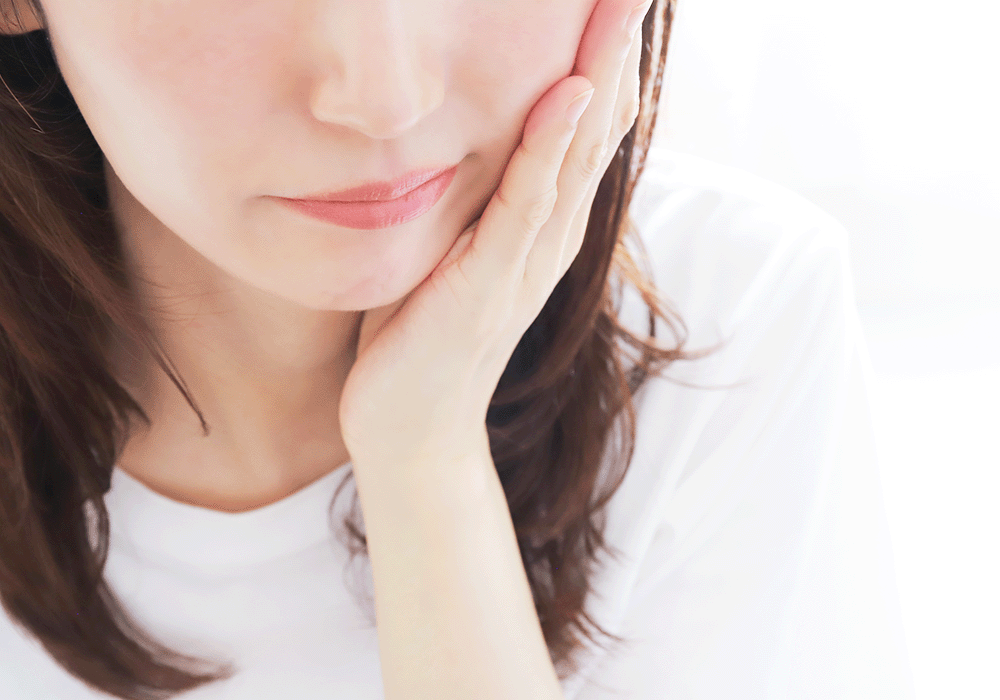 頬を抑える女性