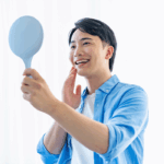 笑顔で鏡を見る男性