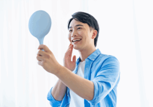 笑顔で鏡を見る男性