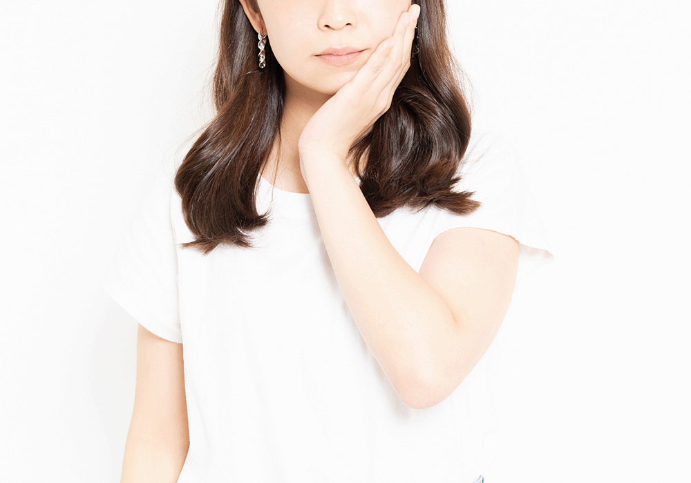 頬を抑える女性